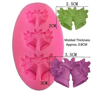 Pink silicone mold for holly bell shapes with finished resin and fondant examples