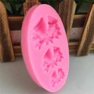 Pink silicone mold featuring three holly leaf shapes for fondant and cake decorating