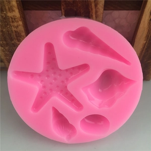 Pink silicone marine life mold featuring starfish, seashell, and conch shapes for fondant cake