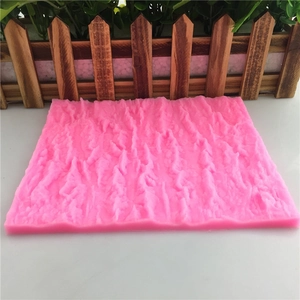 Pink silicone mold featuring detailed tree bark texture for fondant cake decoration