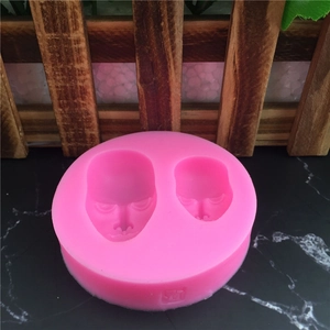 Pink silicone mold featuring two face shapes for fondant cake decorating and DIY crafts