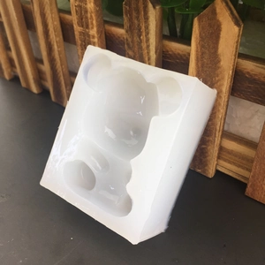Translucent 3D bear silicone mold for chocolate, soap, and handmade crafts on a dark table