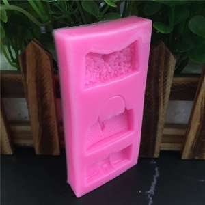 Pink rectangular silicone mold with three different bag-shaped cavities for cake decorating