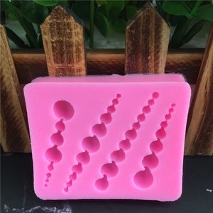 Stampo in silicone rosa con forme di perle di varie dimensioni per decorazioni di torte