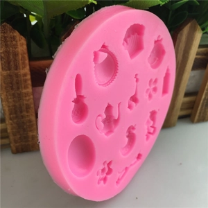 Pink round silicone fondant mold with miniature teapot and flower shapes for baking