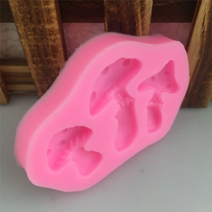Close-up of pink silicone mushroom mold with three detailed fungal shapes for DIY fondant