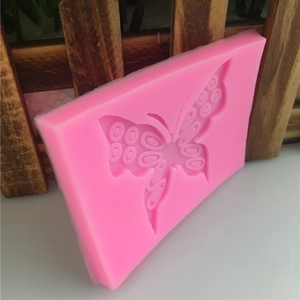 Pink butterfly silicone mold for fondant and DIY baking cakes on a rustic background