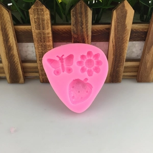 Pink silicone mold featuring detailed butterfly flower and strawberry shapes for cake decoration