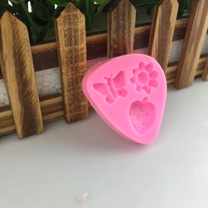 Pink silicone mold with butterfly strawberry and flower shapes for cake decorating