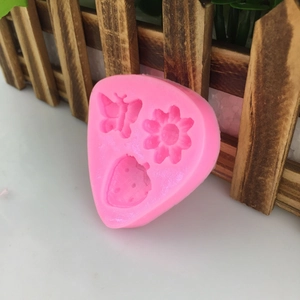 Pink silicone mold with butterfly, flower and strawberry shapes for cake decoration