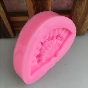 Detail of pink silicone folding fan mold with intricate traditional textured patterns