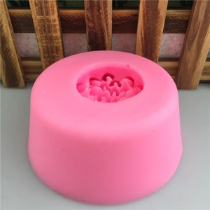 Pink floral silicone mold for handmade soap and cake fondant on white surface