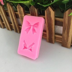 Moule en silicone rose avec deux motifs de nœuds pour décoration de gâteaux et artisanat