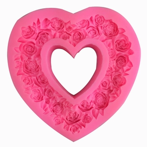 Pink heart-shaped silicone mold with detailed rose flower patterns for cake decorating