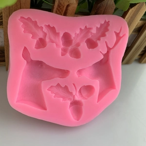 Pink silicone Christmas mold with reindeer and holly leaf patterns for DIY cake fondant