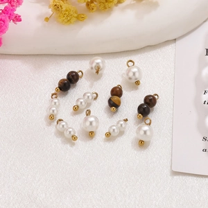 Detalle de colgantes de perlas y ojo de tigre para joyería DIY con ganchos dorados