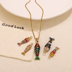 Colorful koi fish pendants in gold finish displayed on a decorative aesthetic surface