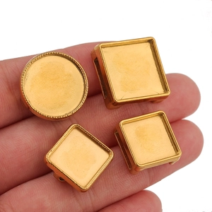 Polished gold stainless steel jewelry base trays held in hand for DIY crafting projects