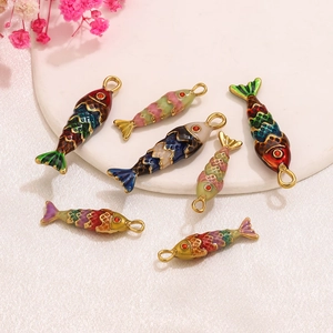 Macro detail of colorful enamel koi fish charms with red crystals on a display tray