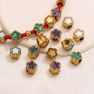 Detailed view of gold star-shaped jewelry beads with colorful enamel and pavé stones