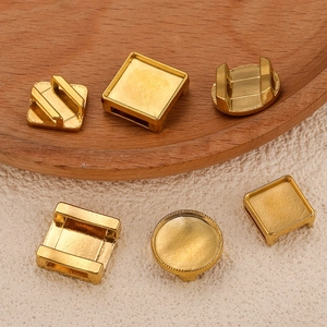 Golden stainless steel bridge slider charms for DIY jewelry making on textured background
