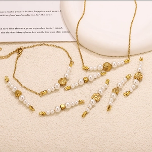 Detailed shot of pearl necklace and bracelet with vintage gold floral connectors