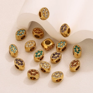 Dettaglio di perline distanziatrici ovali in acciaio inossidabile dorato con strass colorati