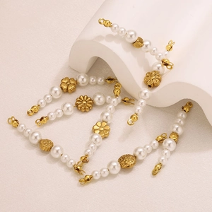 Macro detail of golden flower beads and white pearls for DIY jewelry making sets