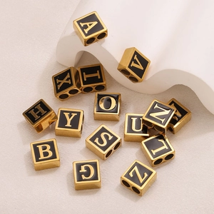 Macro view of 18K gold-plated stainless steel square letter beads with black enamel finish
