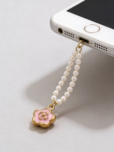 Detail view of pink enamel camellia phone charm with gold trim and white pearls