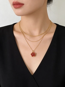 Close-up of layered 18K gold-plated necklace with a red camellia flower pendant on model