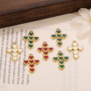 Detailed macro view of heart-shaped cross charms with colorful oil drip finish for DIY jewelry