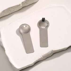 Close-up of polished stainless steel modular bracelet tools on white stone display base