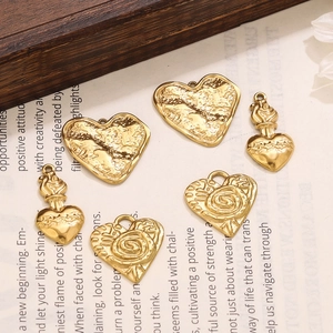 Detailed macro view of vintage gold heart charms with rose patterns on a book background