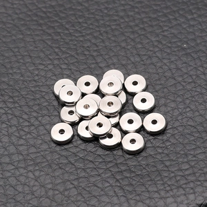 Montón de cuentas espaciadoras de acero inoxidable para hacer joyas sobre cuero negro
