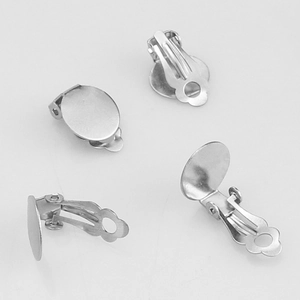 Macro view of four silver stainless steel clip-on earring bases for DIY jewelry making