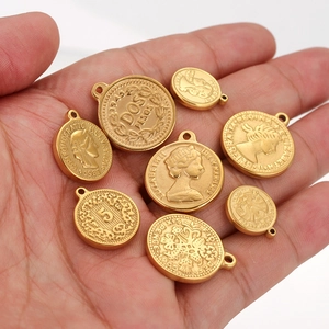 Vintage gold coin pendants with Elizabeth II and Dos Pesos relief on palm of hand