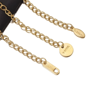 Macro view of gold stainless steel extension chains with S.STEEL engraved geometric tags
