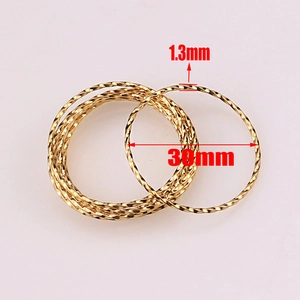 Makro-Detail von 30mm goldenen Edelstahlringen mit Spiralmuster für DIY-Schmuckzubehör