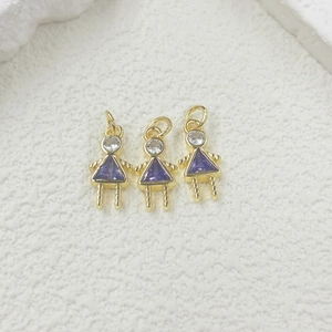 Detailed view of three gold girl-shaped pendants with purple triangle zircons for DIY