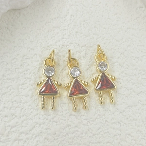 Detailed view of three gold pendants with red triangle zircons for DIY jewelry