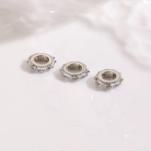 Detailed view of silver spacing beads with set rectangular clear zircon stones