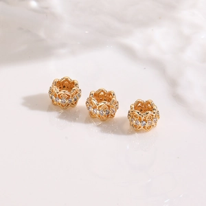 Macro shot of three gold-plated flower spacer beads with pavé cubic zirconia for DIY jewelry