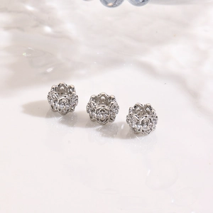 Detailed macro of three silver-plated hollow beads with pavé zircon stones for DIY jewelry