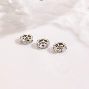 Macro shot of silver plated 18K spacer beads with diagonal engraving and white zircons
