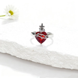 Détail macro de la bague couronne coeur rouge avec des textures d'épines sur pierre