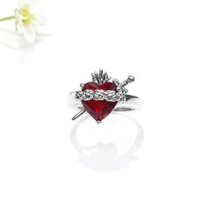 Détail macro de la bague Coeur Sacré avec zircon rouge et design de couronne
