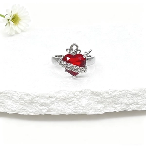 Détail d'une bague couronne avec cœur en zircon rouge et design épine sur pierre