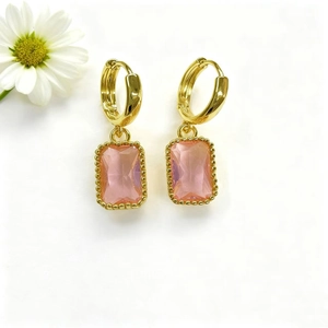 Elegante gouden oorbellen met rechthoekige roze kristallen en decoratieve madeliefje