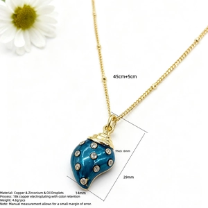Dettaglio del ciondolo conchiglia placcato oro 18k con smalto blu e pietre di zircone